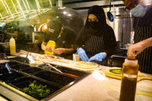 Pizza handlers putting together orders at the counter. Photo: Coconuts