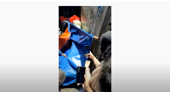 Bystanders taking photos of the suicide victim’s dismembered leg on an alley behind Ambassador Mall in Setiabudi, South Jakarta on March 22, 2021. Photo: Video screengrab