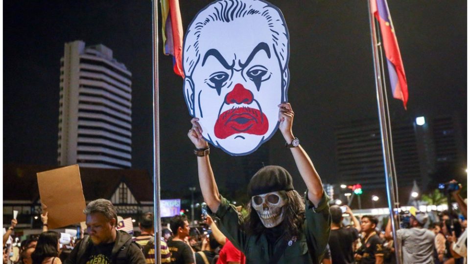 Fahmi Reza holds his artworks depicting Prime Minister Muhyiddin Yassin in clown makeup. Photo: Fahmi Reza/Twitter
