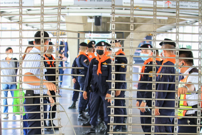 Police and private security contractors observe a metal gate damaged in October near BTS Chidlom on the skywalk above Ratchaprasong Intersection. Photo: Coconuts