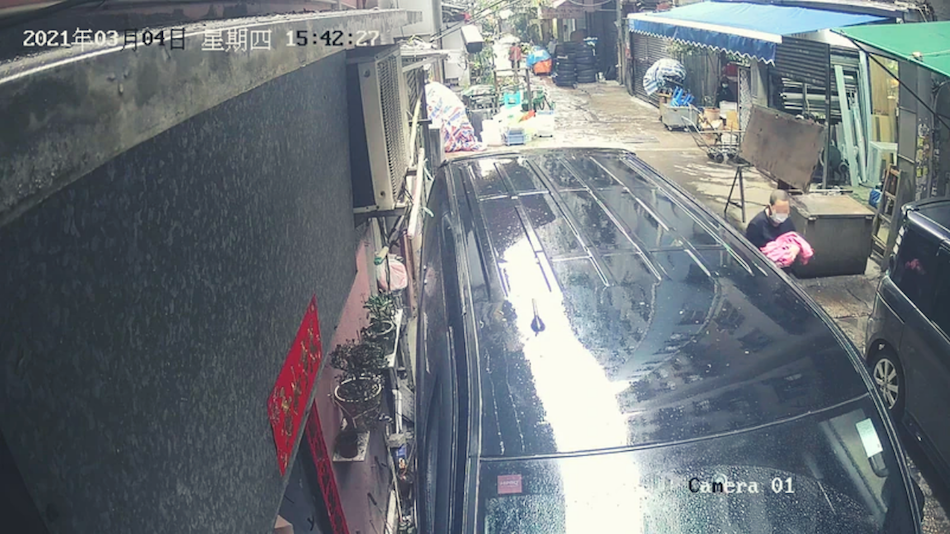 A woman is seen carrying a pink blanket into the To Kwa Wan building, then walking out empty-handed. Photo: Apple Daily