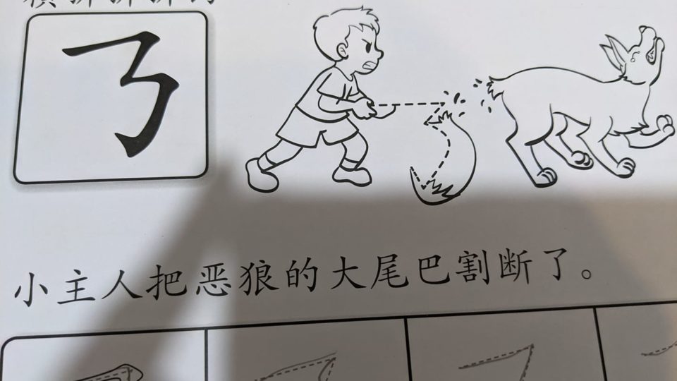 An illustration in a Chinese-language workbook of a boy severing a wolf’s tail. Photo: Facebook
