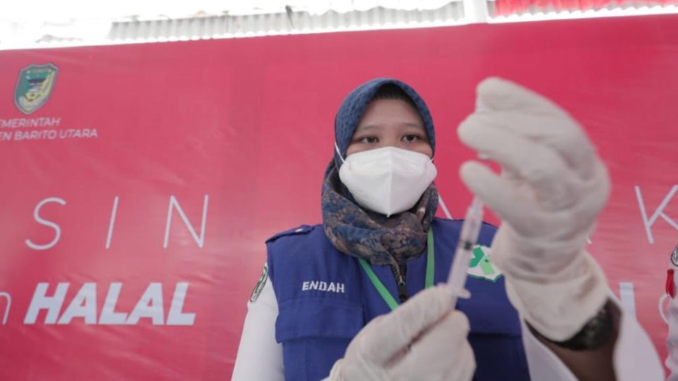 An Indonesian health worker holding a COVID-19 vaccine. Photo: Health Ministry