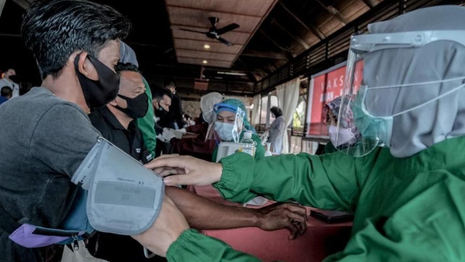 Photo of a health worker checking on a patient’s vitals prior to vaccination. Photo: Ministry of Tourism and Creative Economy