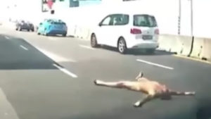 Screengrab of the video of a naked man lying on the road yesterday. Photo: ROADS.sg/Facebook