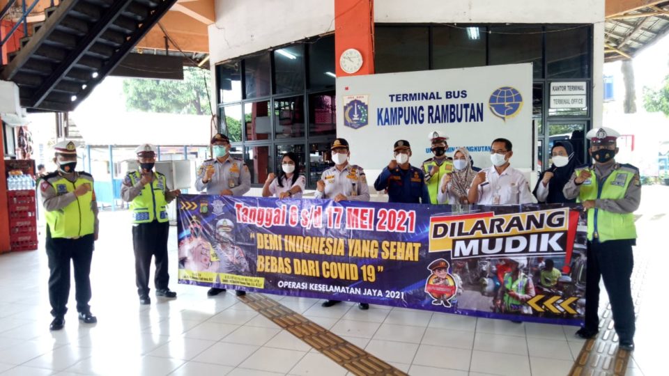 Kampung Rambutan bus station staff and police officers show off a banner announcing the May 6-17 mudik ban. Photo: Twitter/@TMCPoldaMetro