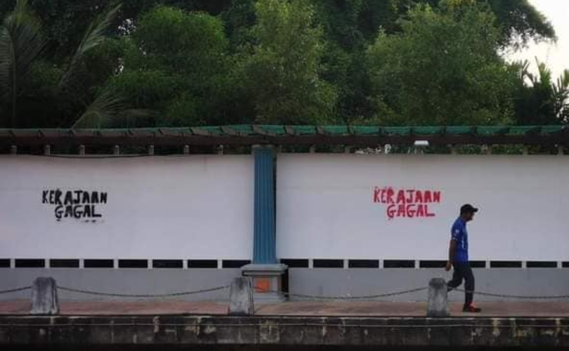 A person walking past the ‘Kerajaan Gagal’ graffiti. Photo: Natural Disasters of Pahang/Facebook
