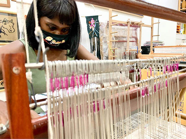 Kavitha weaves at a Wonder Women Loom meetup.