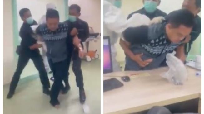 Security guards and hospital staff restraining a disorderly COVID-19 patient at Pasar Minggu General Hospital in South Jakarta. Photo: Video screengrab