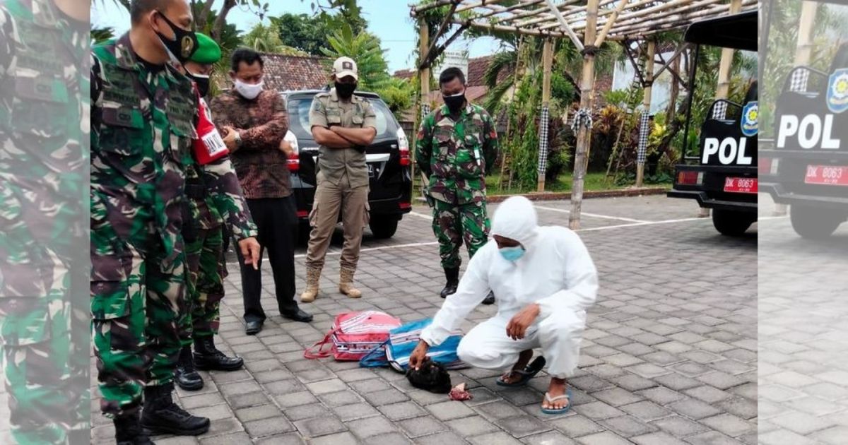 A man in Sukasada district, Buleleng regency was fined and made to wear a hazmat suit for a couple of hours as punishment for allegedly holding a cockfight amid the tightened restrictions being imposed islandwide. Photo: Kodim 1609 Buleleng