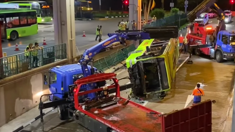 Tow trucks attending to the toppled bus at Bukit Batok interchange last night. Photo: Afiq Azman/YouTube
