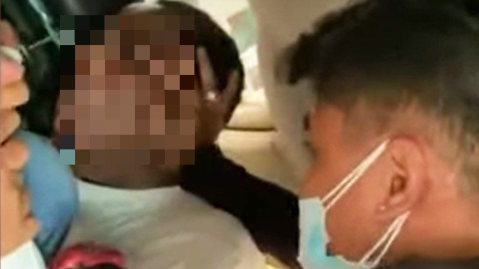 An Indonesian immigration officer pinning the head of a Nigerian consular officer against a car seat in an incident that has triggered diplomatic tensions between the two countries. Photo: Video screengrab