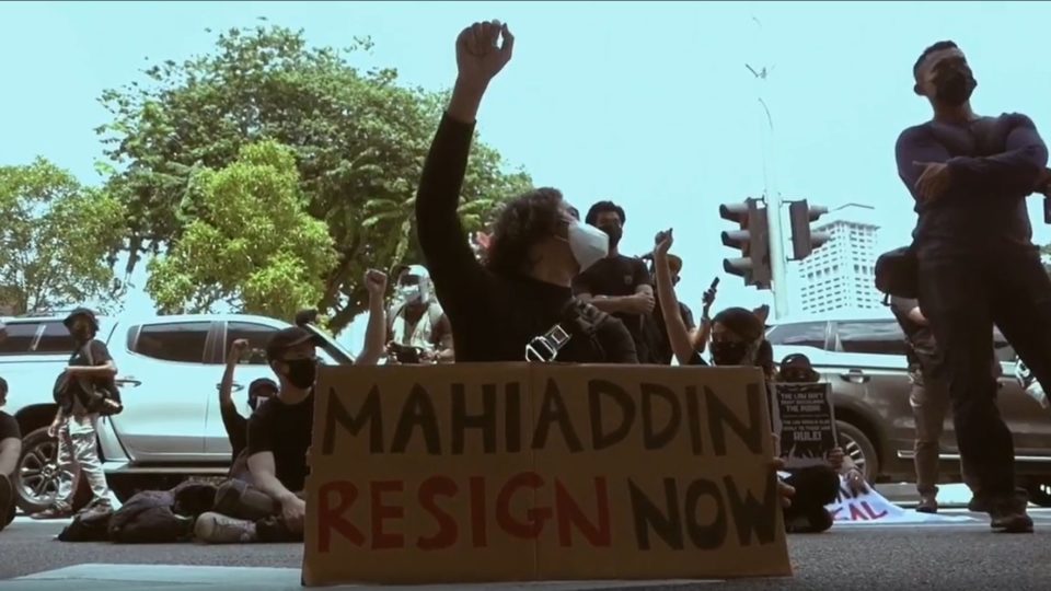 Malaysia protester holds a placard with ‘Mahiaddin Resign Now.’ Photo: Ell Zulkarnain