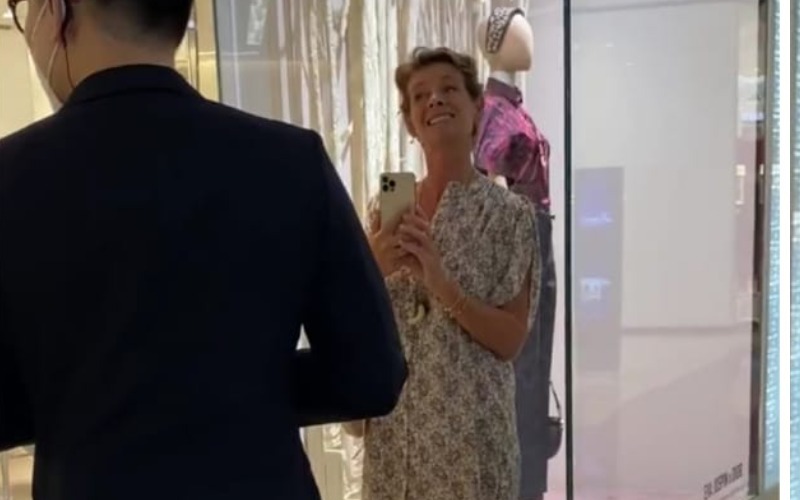 An unidentified woman armed with smartphone and razor-wire grin argues with staff Wednesday in front of Dior KLCC. The police say she faces a sizable fine for violating public health measures. Image: DFEfiercefun / Twitter
