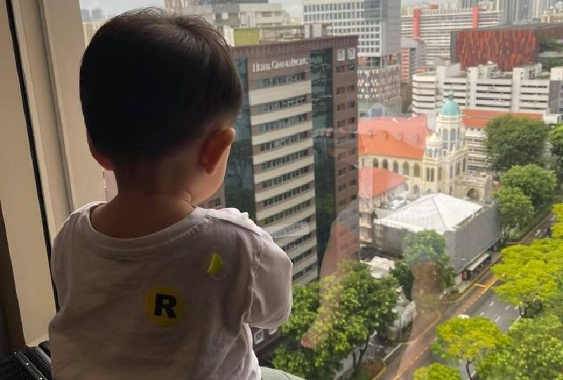 Ivan Tay’s 1-year-old son looks out the window of the Carlton Hotel. Photo: Pearl Pearl/Facebook