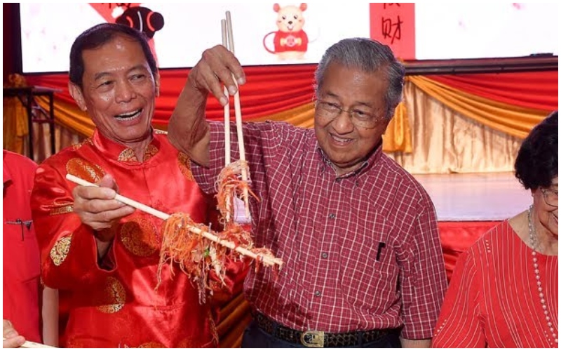 Mahathir Mohamad holds a pair of chopsticks while taking part in a salad toss during Chinese New Year in 2020. Photo: Berita Harian/YouTube
