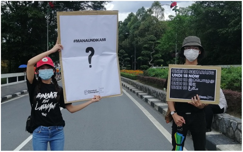 Two voting rights protesters standing outside the Parliament building in March. Photo: Coconuts
