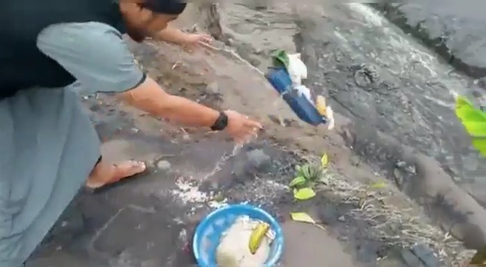 A man tossing and kicking offerings baskets downhill because he believed they incurred Allah’s wrath. Video screengrab