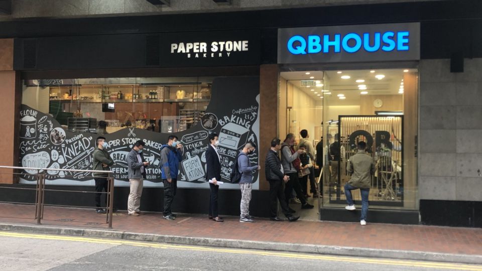 People queuing up to get haircuts outside the Sheung Wan QB House outlet on Feb. 9, 2022.