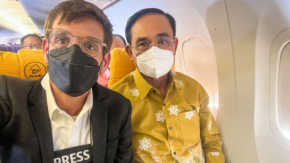 American photojournalist Matt Hunt sits beside Prime Minister Prayuth Chan-ocha in a photo he tweeted from a March 14 press event. Photo: Matt Hunt / Twitter
