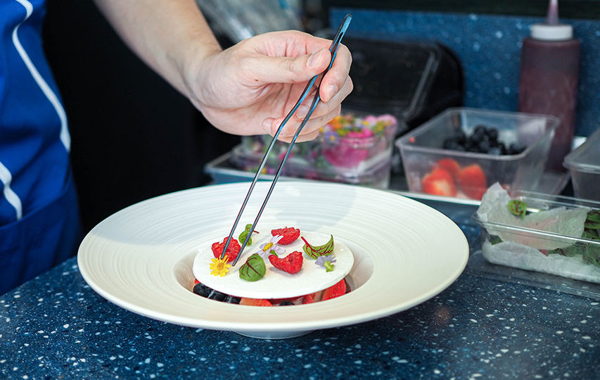 Vacherin (THB330) features vanilla ice cream and raspberry sorbet topped with a meringue plate arranged with fresh raspberries and edible flowers.
