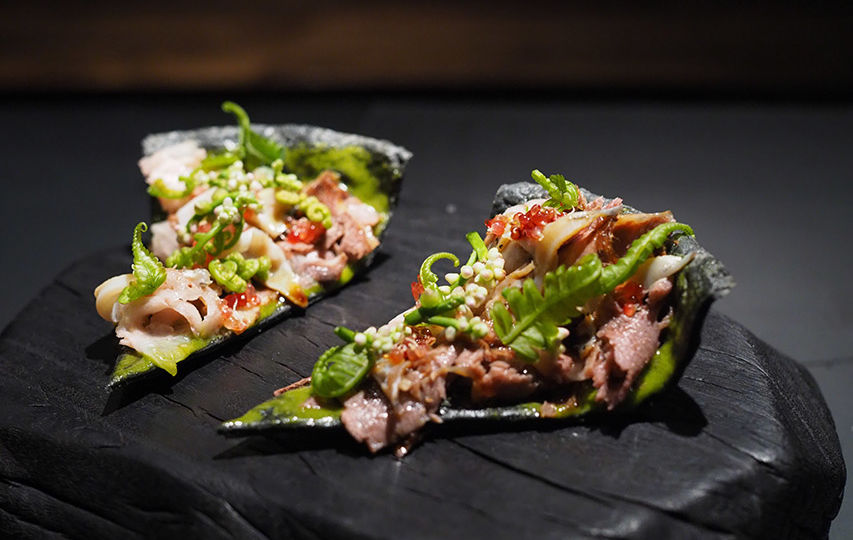 ‘Crying Tiger,’ inspired by a song by Apartment Khunpa, makes use of Isaan ingredients such as pork jowls and wild sweet herbs and comes served in a charcoal tart.
