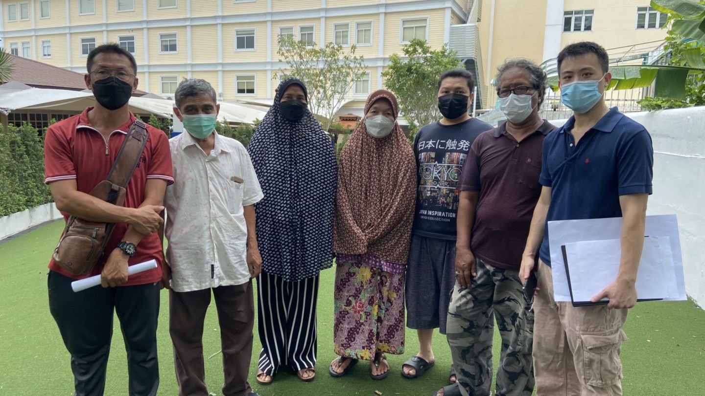 Neighbors of St. Andrews International School gather on a strip of public land behind their homes that has been partially absorbed by the school to sign a petition asking Bangkok’s governor to step in and review their case. Photo: Coconuts