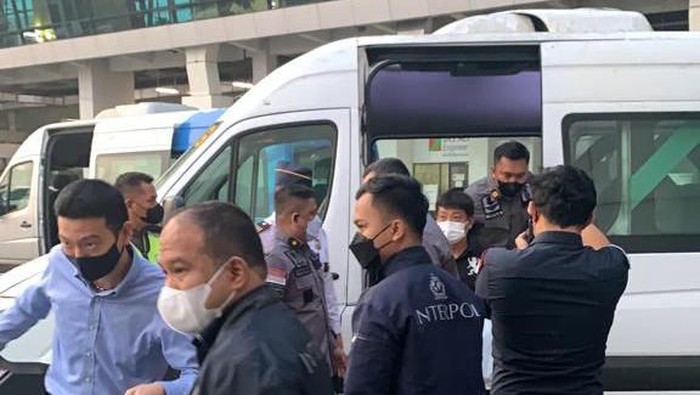 Officers escorting MT to the airport. Photo: Handout