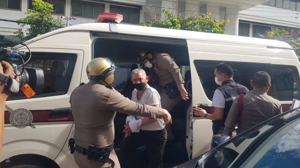 Army Sgt. Maj. Yongyuth Mankornkim, seen bound and exiting a van, is accused of murdering two fellow soldiers in a shooting spree at an army training facility in Bangkok. Photo: Dusit District Police