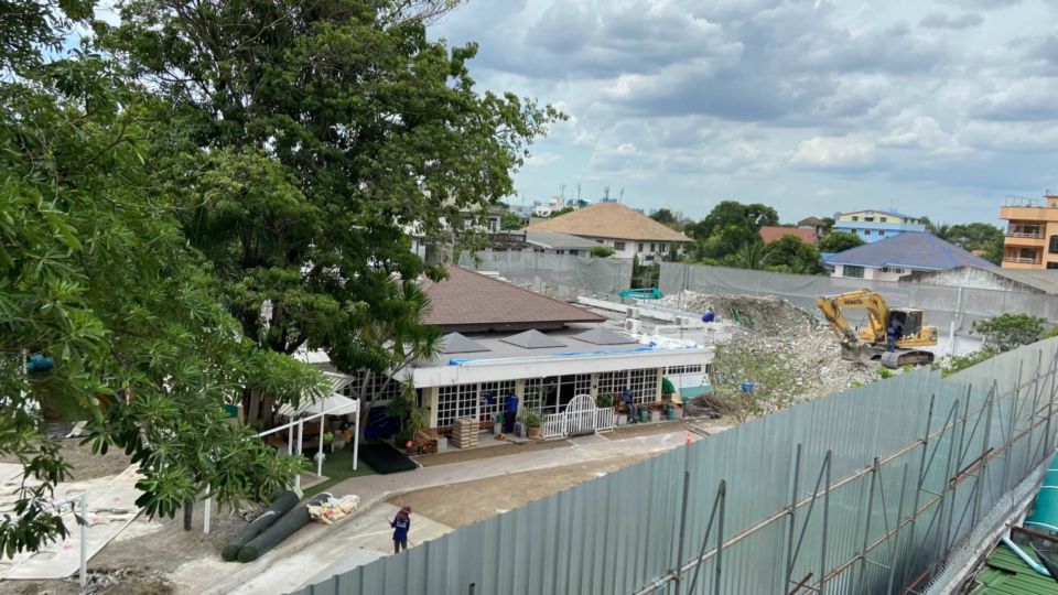 Workers remove a lawn in July that encroached on public land behind St. Andrews International School. Photo: Nicky Tanskul