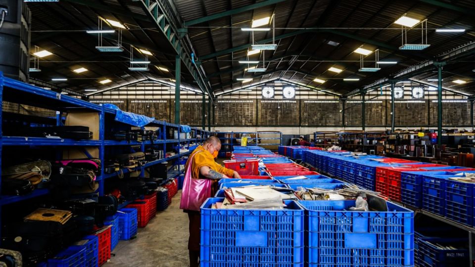 A monk digs through crates of vinyl on Sept. 21, 2022, at Lucky Home warehouse in Bangkok’s Samrong area. Photo: Coconuts Bangkok