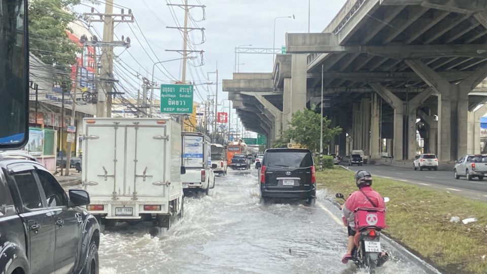Motorists drive through a flooded Bangkok road. Photo: Sok Haingkheang / Coconuts
