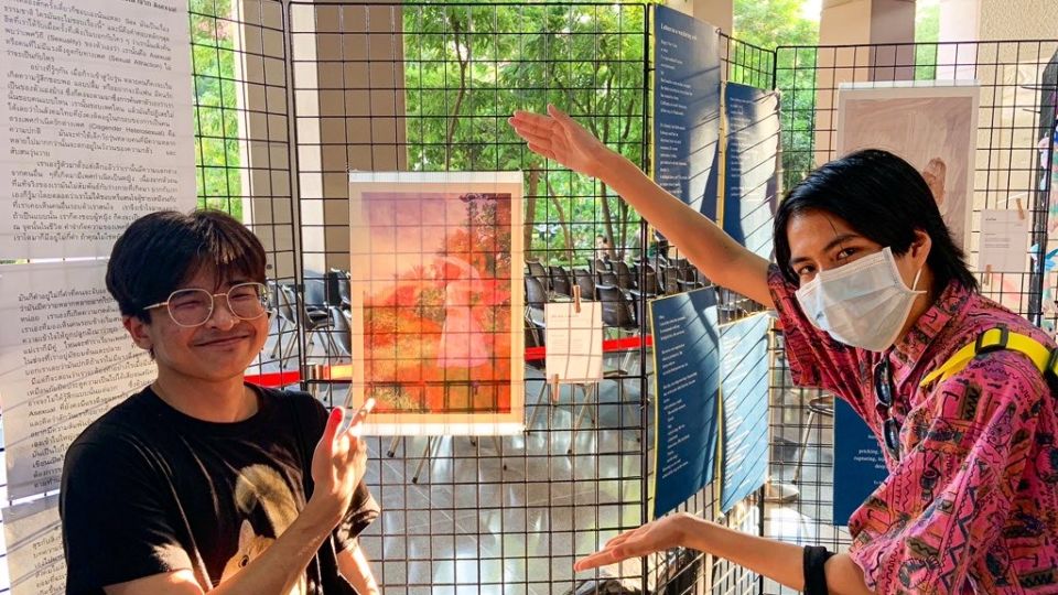 Asexual trans man, Parkers Argasnoum, at left, poses with a photo of him at the event. 