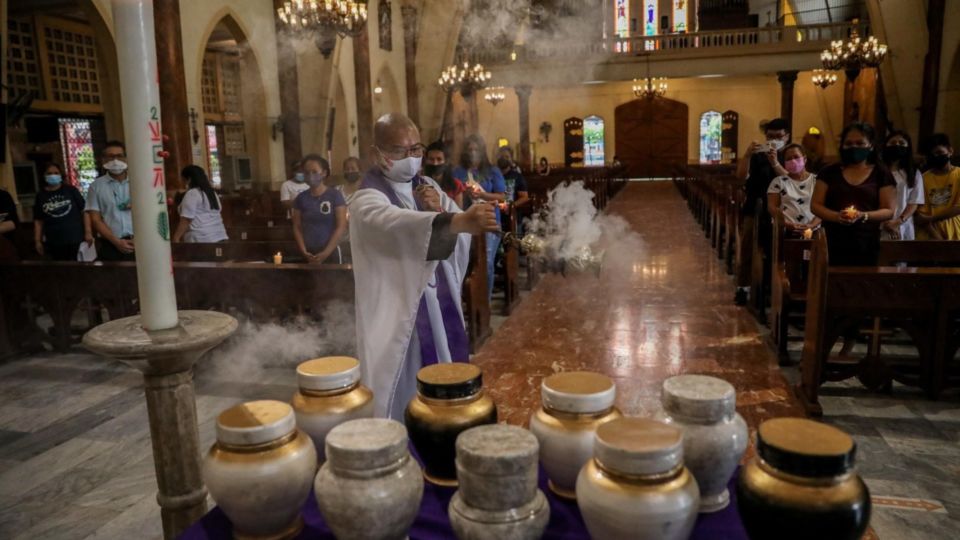 Priest Falviano Villanueva spreads incense over urns containing the ashes of people killed in the Philippine government’s war on drugs, during a Mass for their families at a Catholic church in Manila, Nov. 15, 2021. Photo: Basilio Sepe/BenarNews