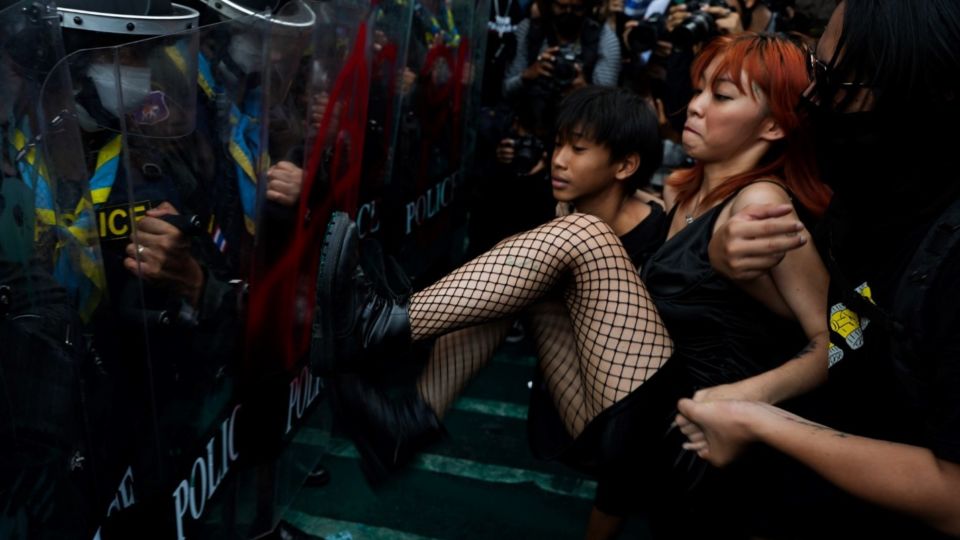 A woman stomps on a Thai police riot shield as pro-democracy demonstrators attempt to gain access to the venue of the APEC leaders’ summit near Asoke intersection in Bangkok, Nov. 17, 2022. Photo: Nontarat Phaicharoen/BenarNews