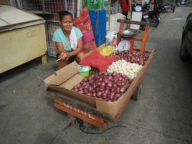 A female seller peddles onions in the Philippines. Onions have skyrocketed to as much as PHP700 a kilo in the country. Image: Wikimedia Commons