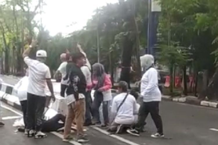 Participants surround the victim after her head collided with a road separator. Photo: Video screengrab