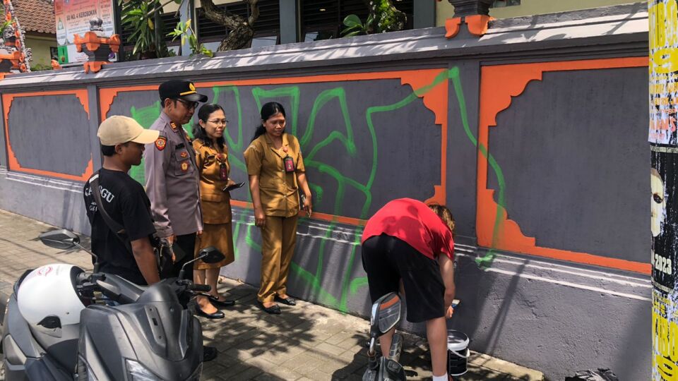 A Russian teenage boy who was caught spraying graffiti on the wall of an elementary school in Kerobokan on Jan. 28 was forced to repaint the wall two days later. Photo: Obtained.