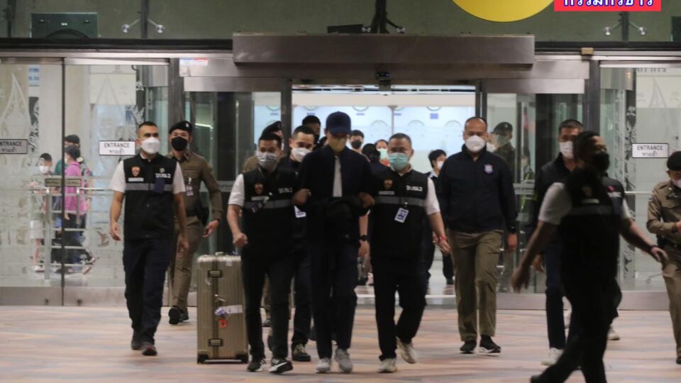 Officers escort Chaiwat Kajornboonthavorn, aka Benz Daemon, last night out of Bangkok’s Suvarnabhumi International Airport. Image: News Talk