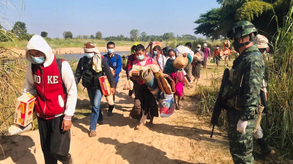 In this photo provided by Thailand’s Ministry of Defense taken during the third week of Dec. 2021, Thai soldiers receive Myanmar villagers arriving in Thailand after fleeing clashes between Myanmar troops and an ethnic Karen rebel group in Mae Sot, Tak province, northern Thailand. Fighting between Myanmar government forces and ethnic guerrillas has sent about 4,200 villagers fleeing across the border into Thailand over the past week, a Thai army officer said Wednesday. (Thailand Ministry of Defense via AP)