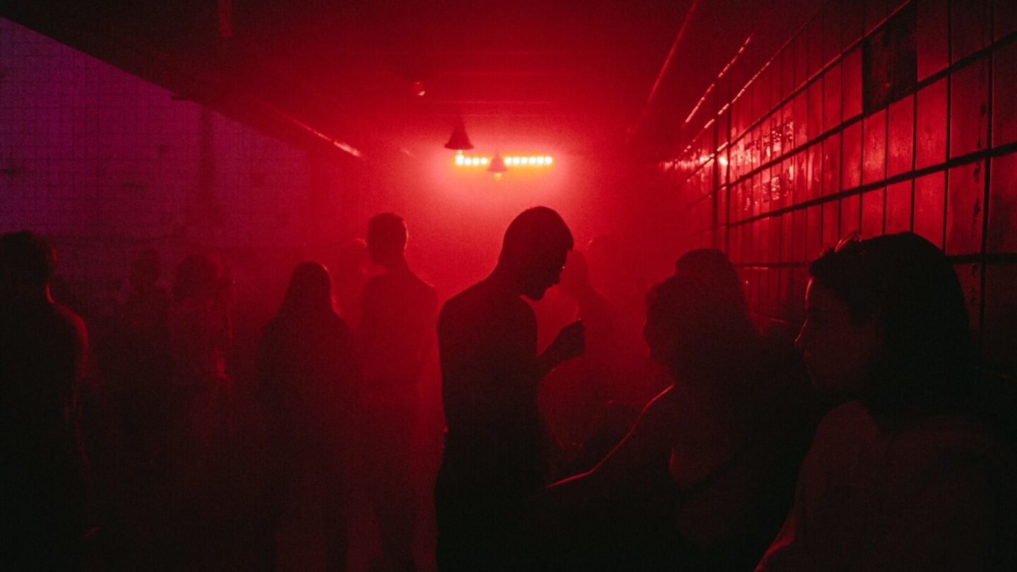 People in a red-lit room. Photo: Unsplash