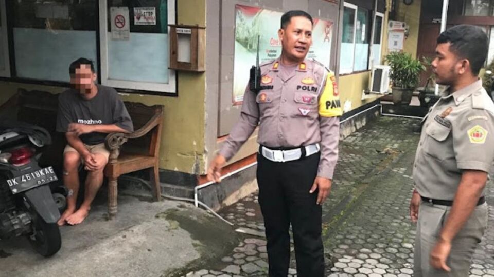 A Russian man (Left) in police custody after he was caught walking on a street in Ubud completely naked. Photo: Handout