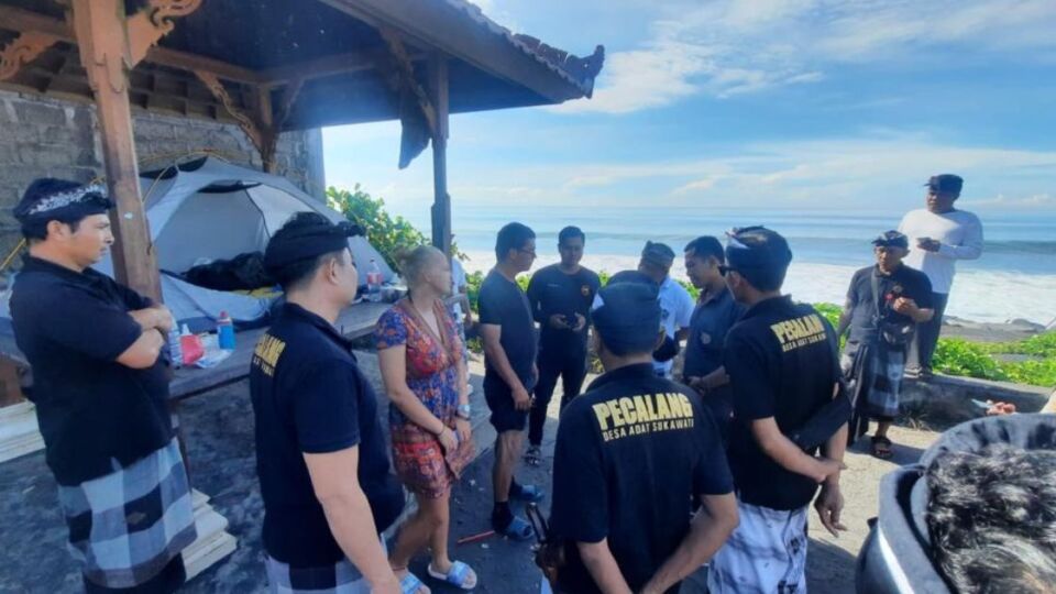 Pecalang officers reprimand a Polish couple for camping outside during Nyepi on March 22, 2023. Photo: Bali Police