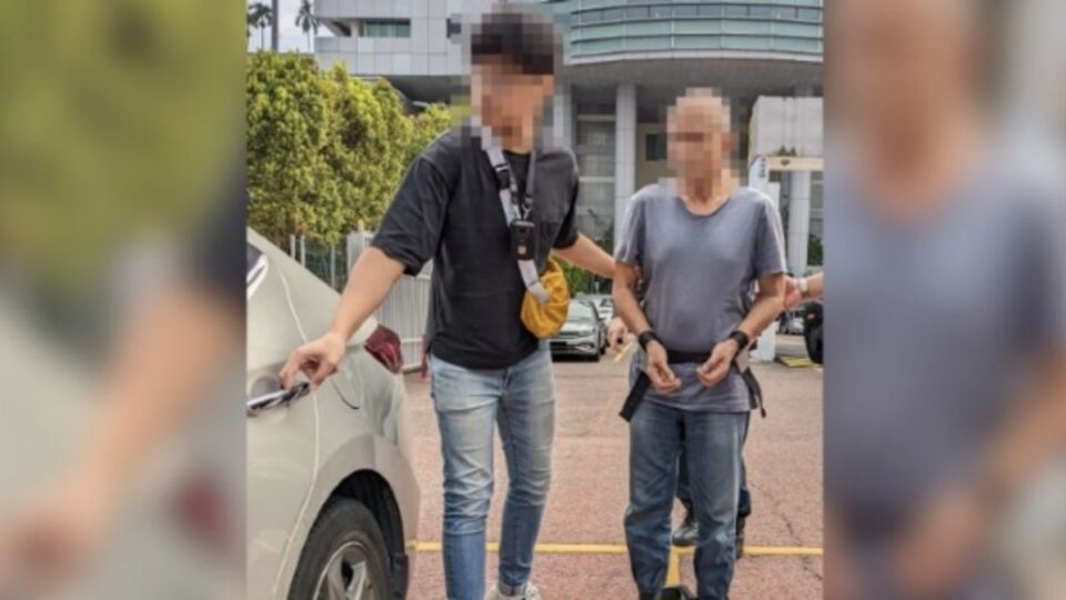 A 56-year-old man with a CNB officer yesterday. Photo: Central Narcotics Bureau (CNB)
