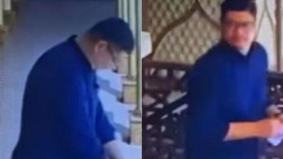 A man placing his QRIS code stickers on donation boxes at a mosque. Photo: Video screengrabs