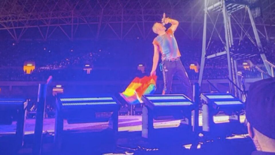 Coldplay frontman Chris Martin holding a Pride flag during a concert in San Jose, California in 2022. Photo: Twitter/@coldplaying