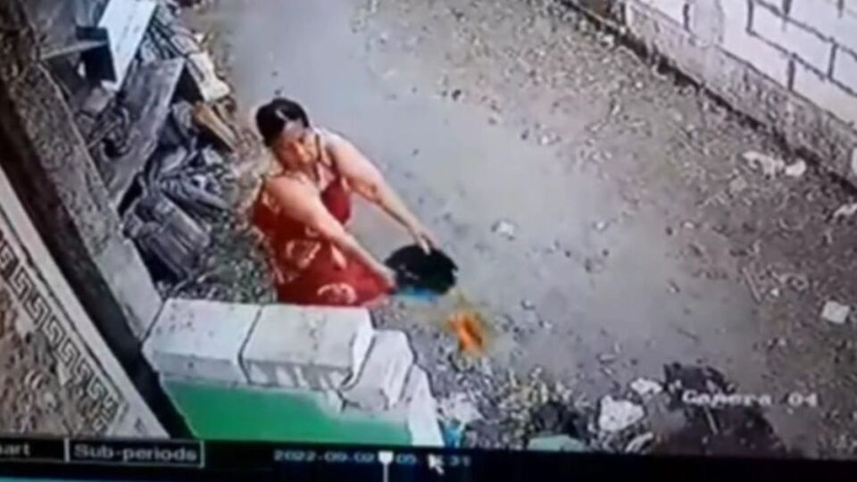 Masriah caught by a CCTV camera tossing urine on her neighbor’s house. Photo: Video screengrab