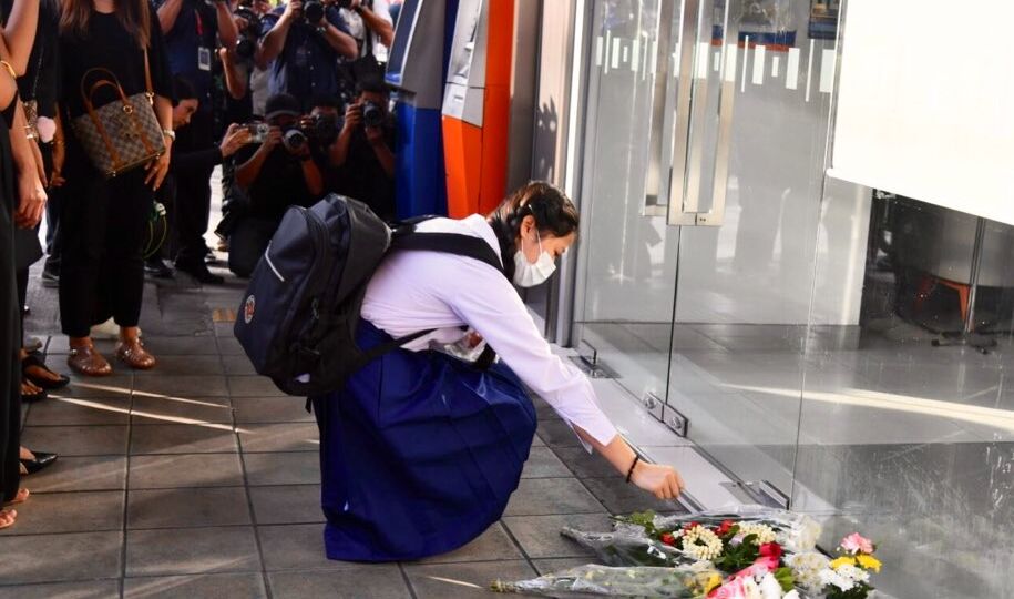 Parents and students of Sacred Heart Convent School laying flowers and paying respects in front of the ATM at TMBThanachart bank on Sunthornkosa road Monday morning, where Sirada “Kru Jeab” Sinprasert was wrongfully killed during a shooting by vocational school students on Saturday.