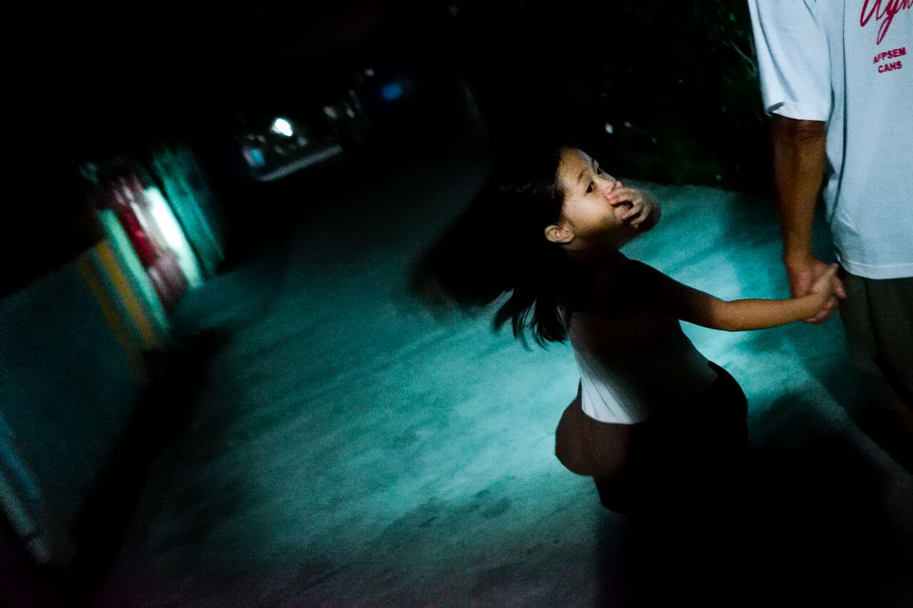 Yolanda's granddaughter walks to 7-Eleven with her grandfather in Tarlac, Philippines. Yolanda spent many years in Hong Kong looking after her employer's children, whom she still misses very much.