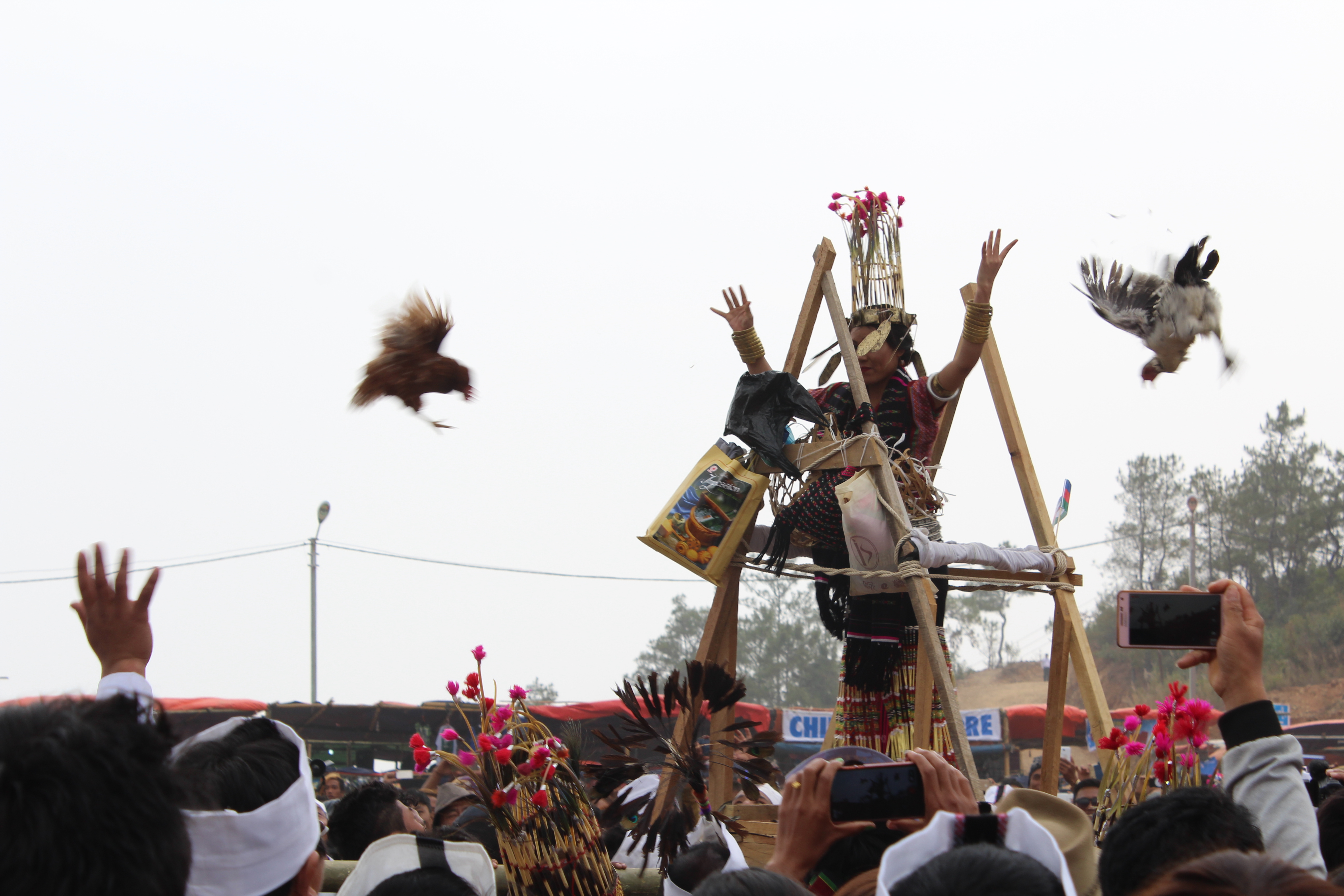 A woman throws chickens into the crowd. Photo: Jacob Goldberg